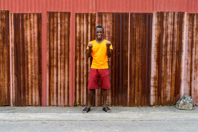 Portrait of smiling man standing against yellow wall