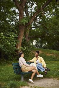 Female friends sitting on bench and talking