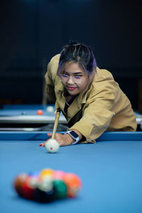 Portrait of woman playing pool