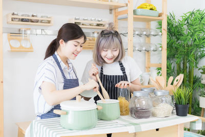 Young woman holding food in kitchen