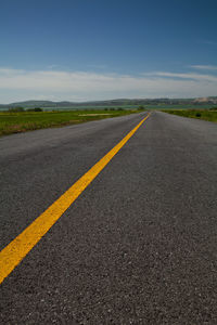 Surface level of road against blue sky