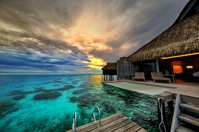 Houses against cloudy sky at sunset