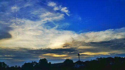 Low angle view of trees against sky at sunset