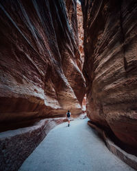 Rear view of man walking on rock formation