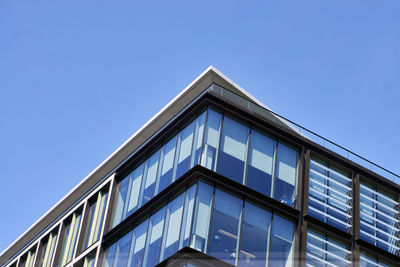 Low angle view of modern building against clear blue sky