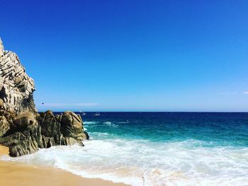 Scenic view of sea against clear blue sky