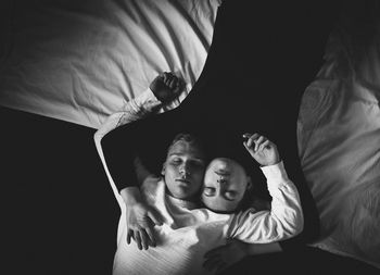 High angle view of couple sleeping on bed