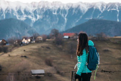 Rear view of woman standing against mountain