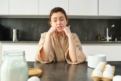 Portrait of young woman sitting on table