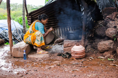 Woman preparing food on stove in village