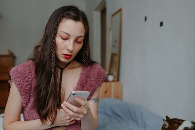 Sad woman with smartphone at home