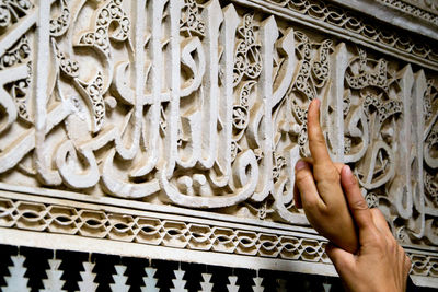 Close-up of human hand against built structure