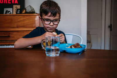 Young boy slowly eating a meal at the kitchen table