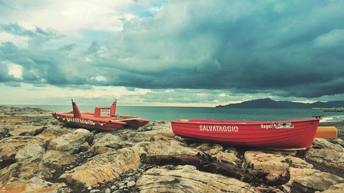 Boat moored on shore against sky