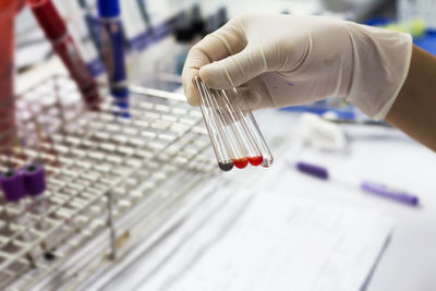 Cropped hand of person holding test tubes at laboratory