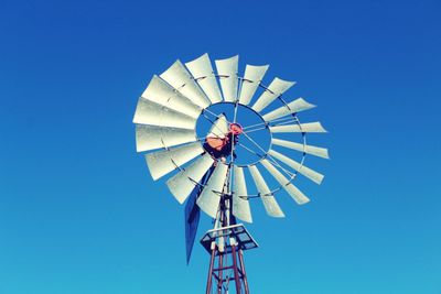 Low angle view of traditional windmill against clear blue sky