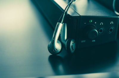 Close-up of in-ear headphones with amplifier on table