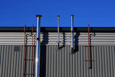 Low angle view of factory against clear blue sky