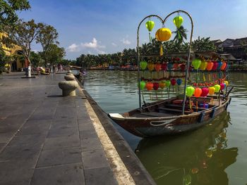 Boats moored in river against sky