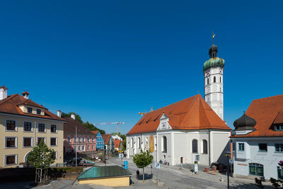 View of buildings in city against clear blue sky