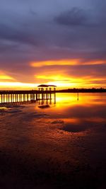 Bridge over sea against sky during sunset
