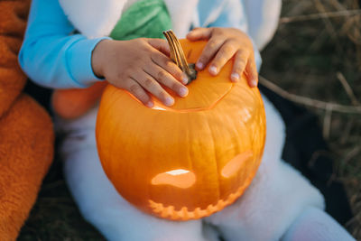 Midsection of woman holding pumpkin during halloween