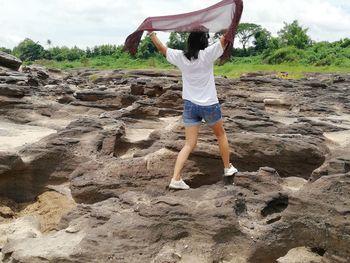 Rear view of woman walking on rock