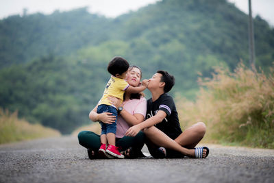 Rear view of mother and daughter on road