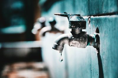 Close-up of water faucet against wall