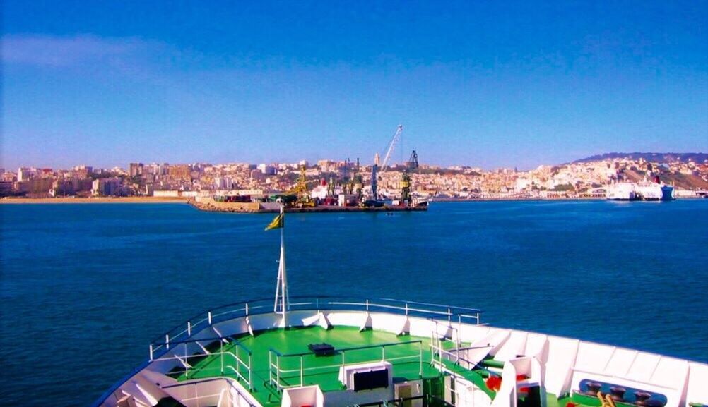 HIGH ANGLE VIEW OF SEA BY CITY AGAINST SKY