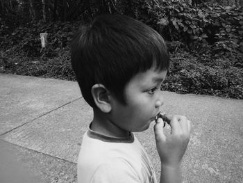 Side view of innocent boy standing on footpath