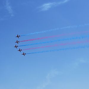 Low angle view of airshow against sky