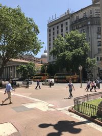 People on street against buildings in city