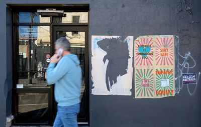 Side view of man standing against wall