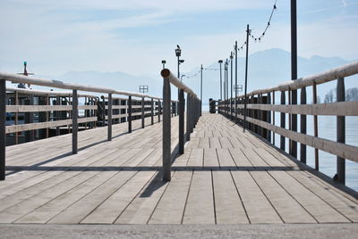 Man on footbridge against sky