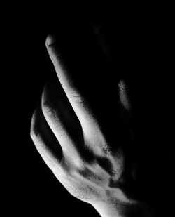 Close-up of human hand against black background