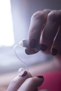 Close-up of hands holding hearing aid