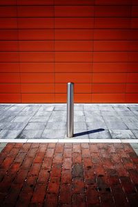 Footpath against brick wall