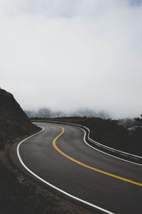 Scenic view of road by mountains against sky