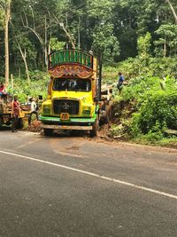 Vehicles on road by trees in city