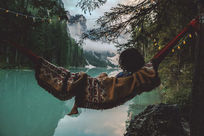 Young woman resting in hammock against lake