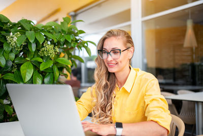 Young woman using laptop at table