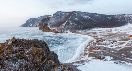 Scenic view of sea by mountains against sky