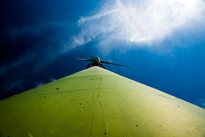 Low angle view of wind turbines against blue sky