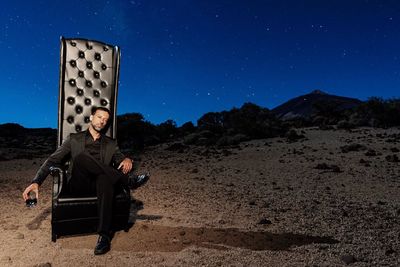Man wearing sunglasses against sky at night