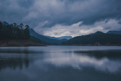 Scenic view of lake by mountains against sky