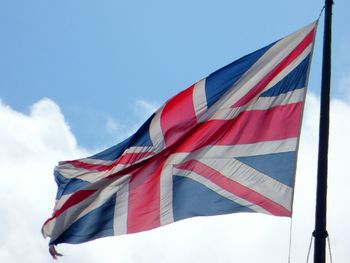 Low angle view of british flag waving against sky