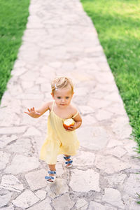 Cute baby girl walking on footpath