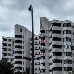 Low angle view of modern building against cloudy sky