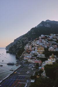 Aerial view of townscape by sea against clear sky